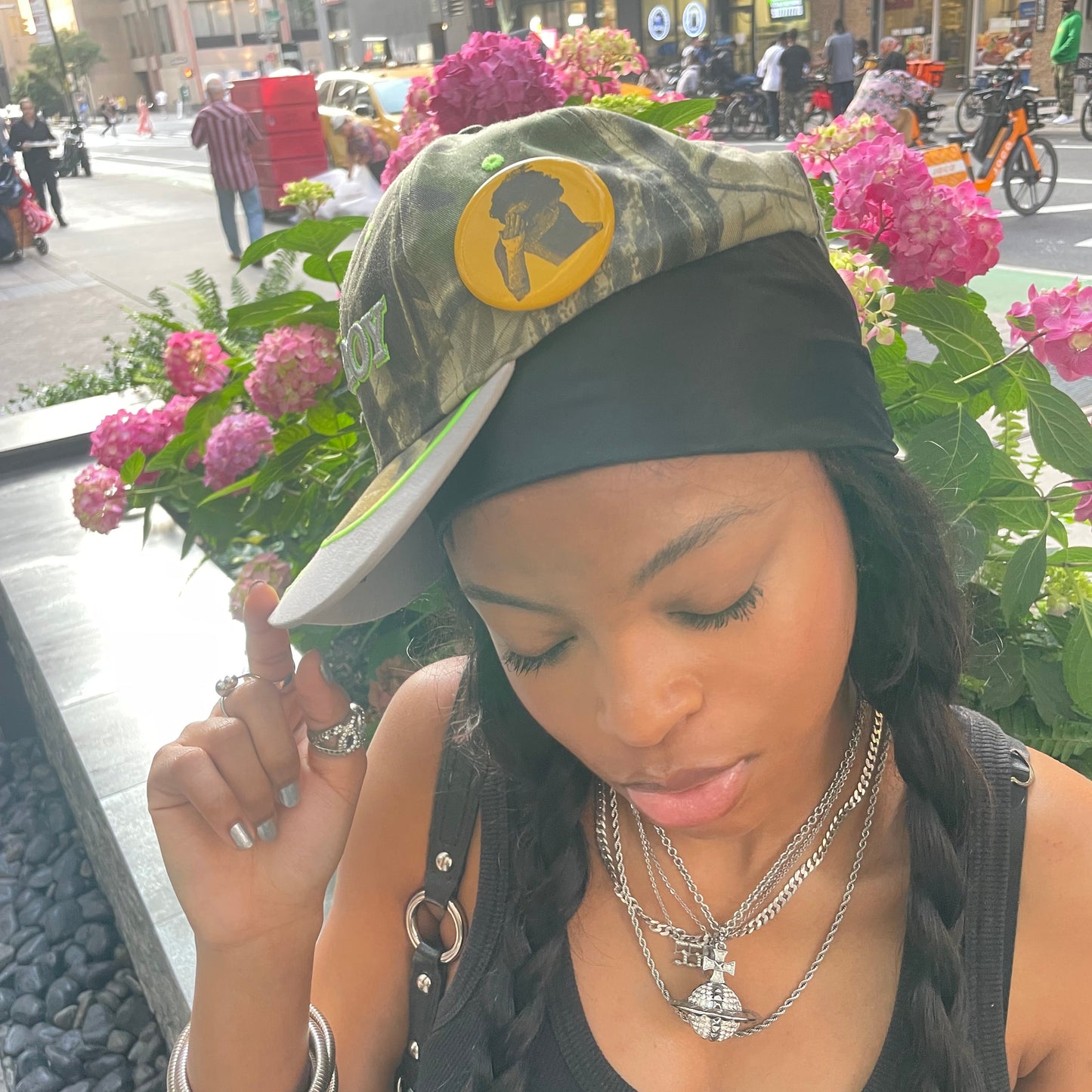 Woman wearing a black headscarf and black top with a cityscape background