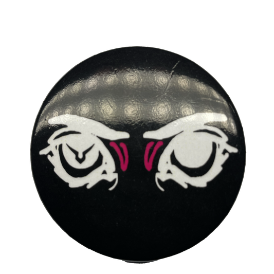 A round pin with a black background featuring an eye design with pink irises and a logo resembling a stylized face in the center.
