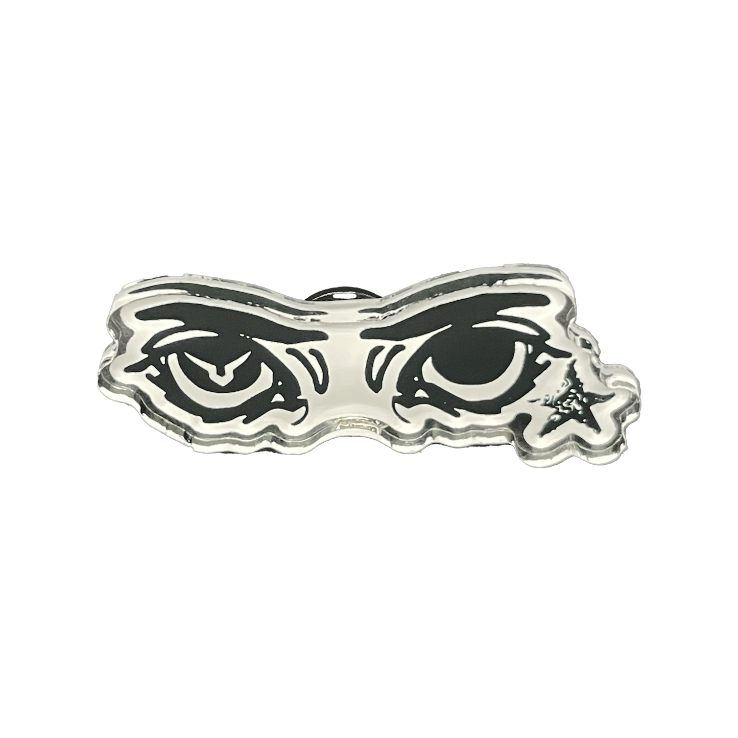 A silver-colored acrylic pin with a soft PVC clutch, featuring a stylized eye design behind a mask-like border.
