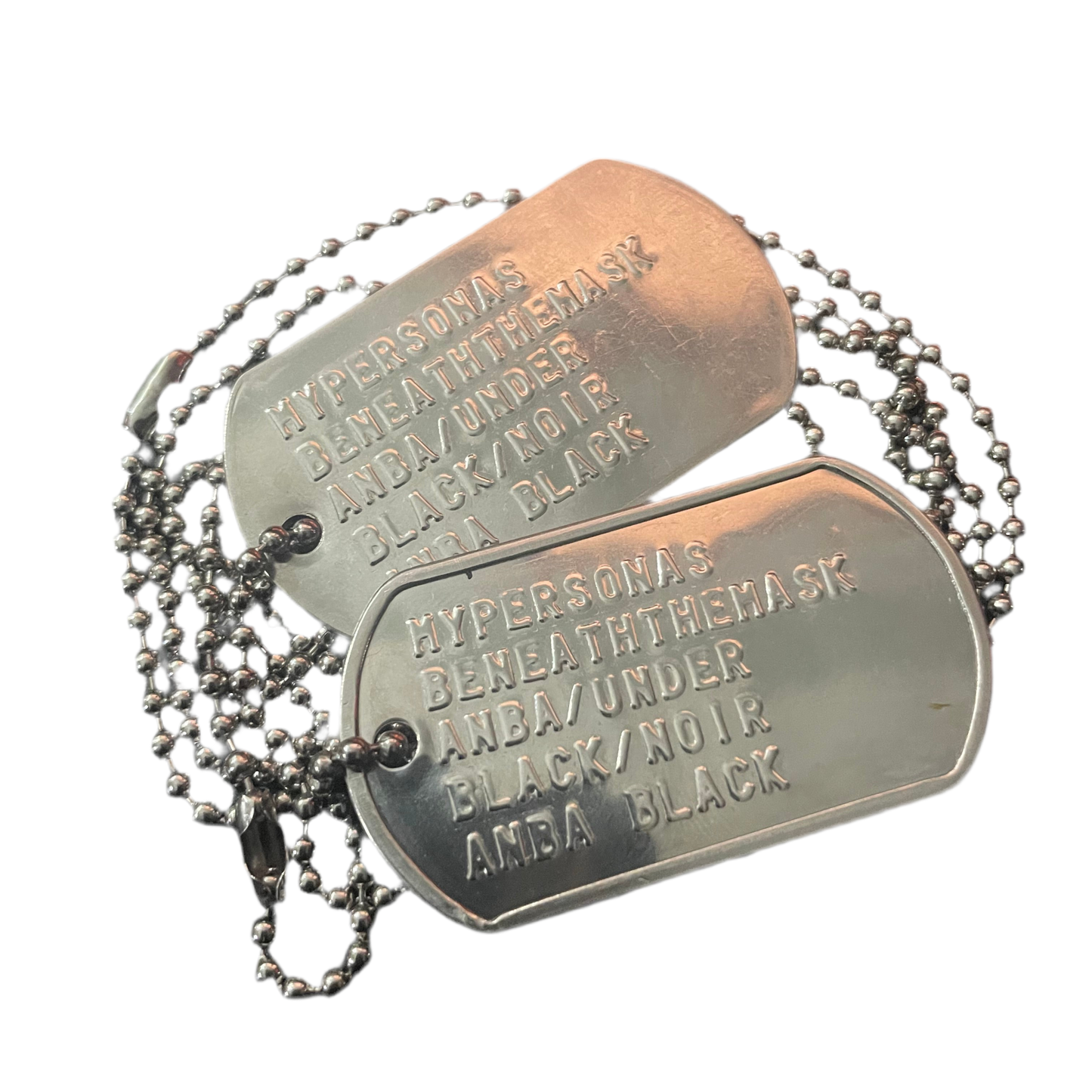 Metal dog tags with engraved text on a white background