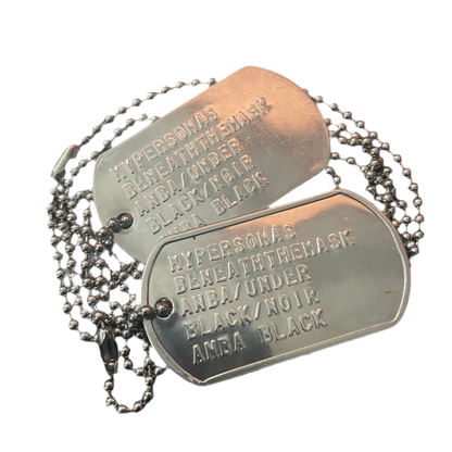 Metal dog tags with engraved text on a white background